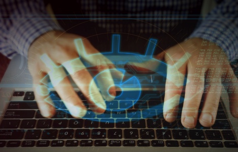Hands on a keyboard with a blue eye icon overlaid on top