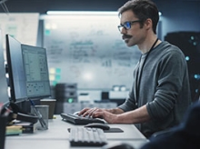 Man with a mustache and glasses working in an office 