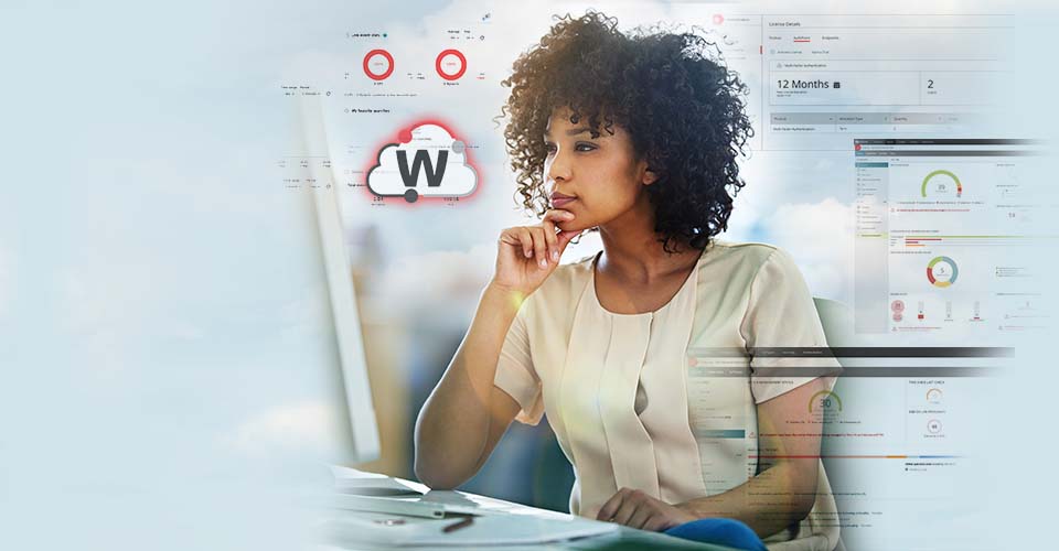Black woman with natural curly hair in a white silk top looking at a monitor with WatchGuard Cloud screens behind her